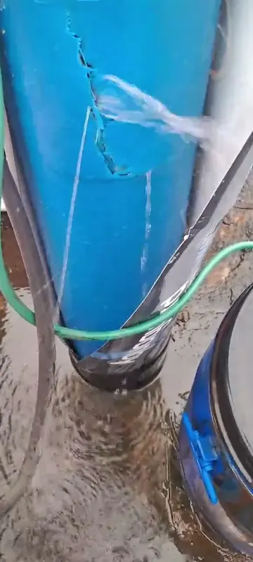 Cracked blue Eureka Forbes Aquaguard water softener vessel with water spraying out